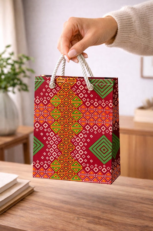 Red, orange, yellow, green, & white handmade African fabric extra small gift bag in lifestyle shot
