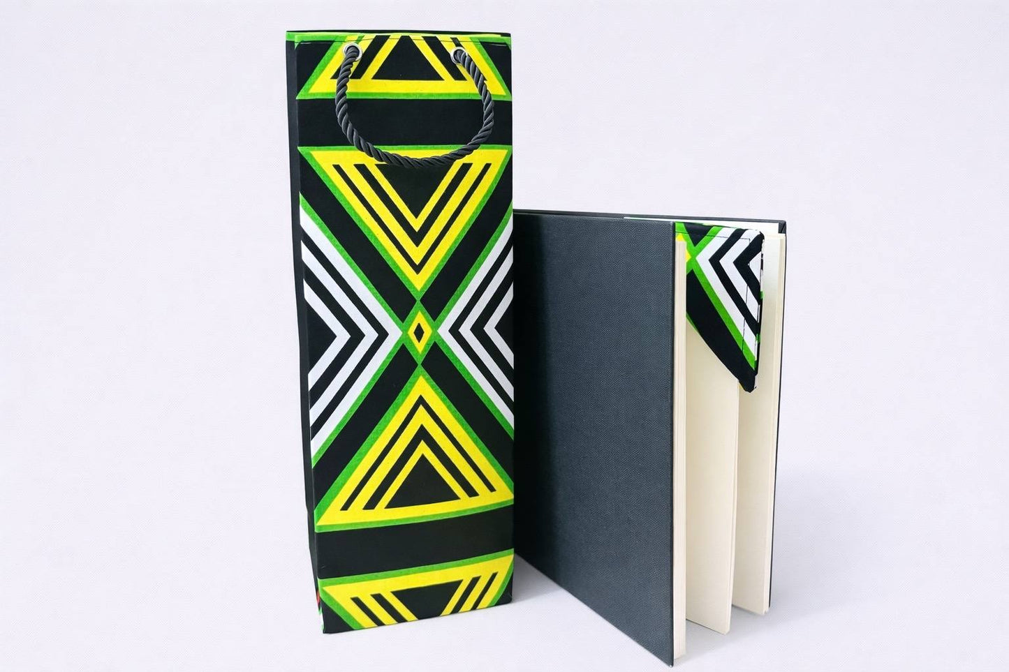 Black, green, white, & yellow wine bag, & corner bookmark on a white background
