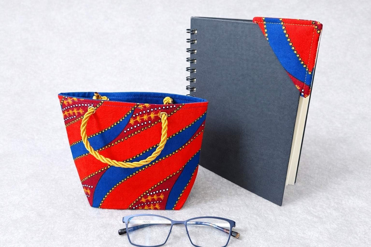 orange, blue, maroon, white, & gold mini tote bag, & corner bookmark on a white background