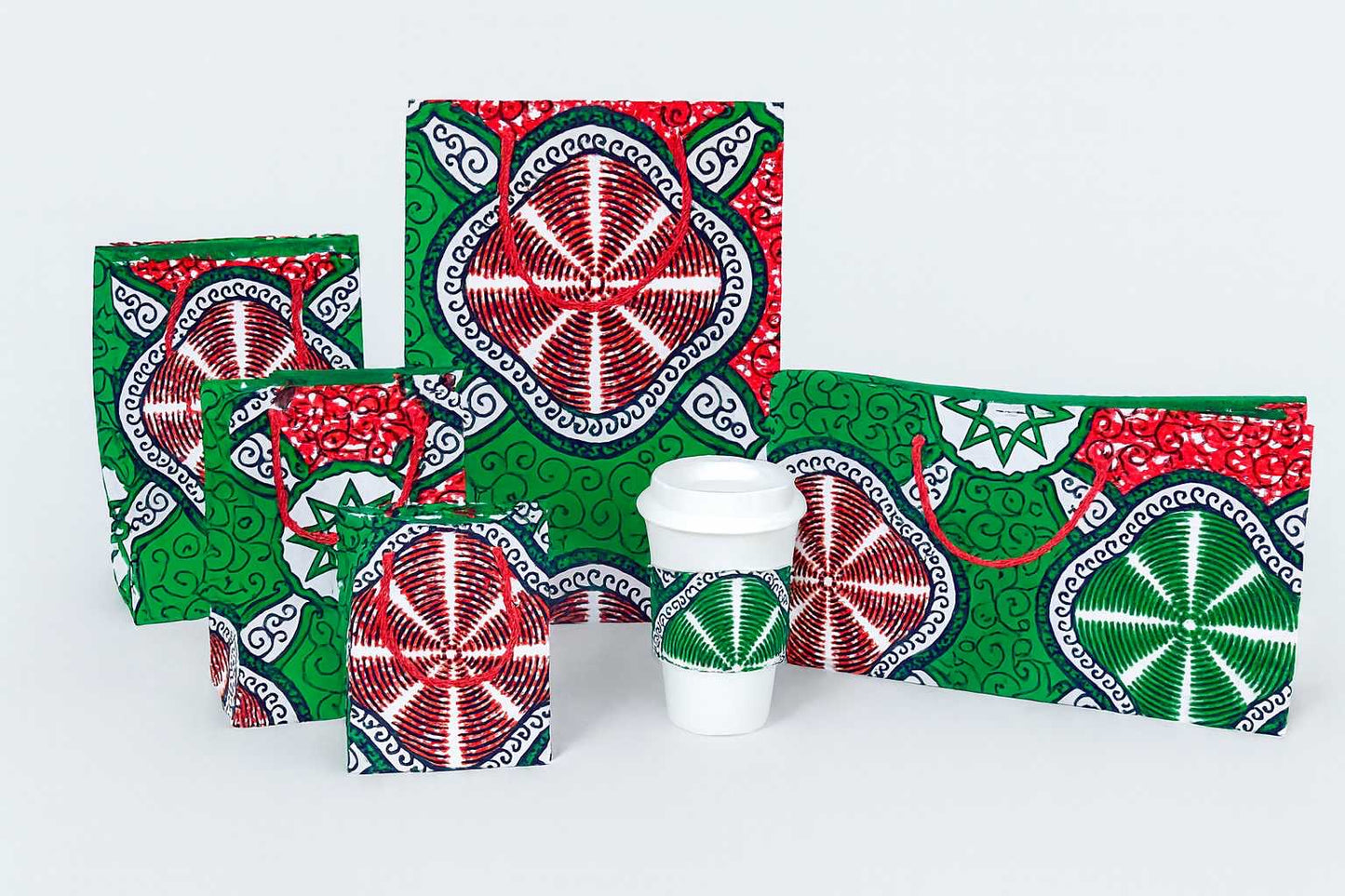 White, black, red, & green medium, small, extra small, and mini square bag, medium horizontal gift bag and cup sleeve on a white background