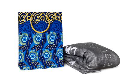 Blue, white, and gold floral-patterned gift bag and gray blanket with text on a white background