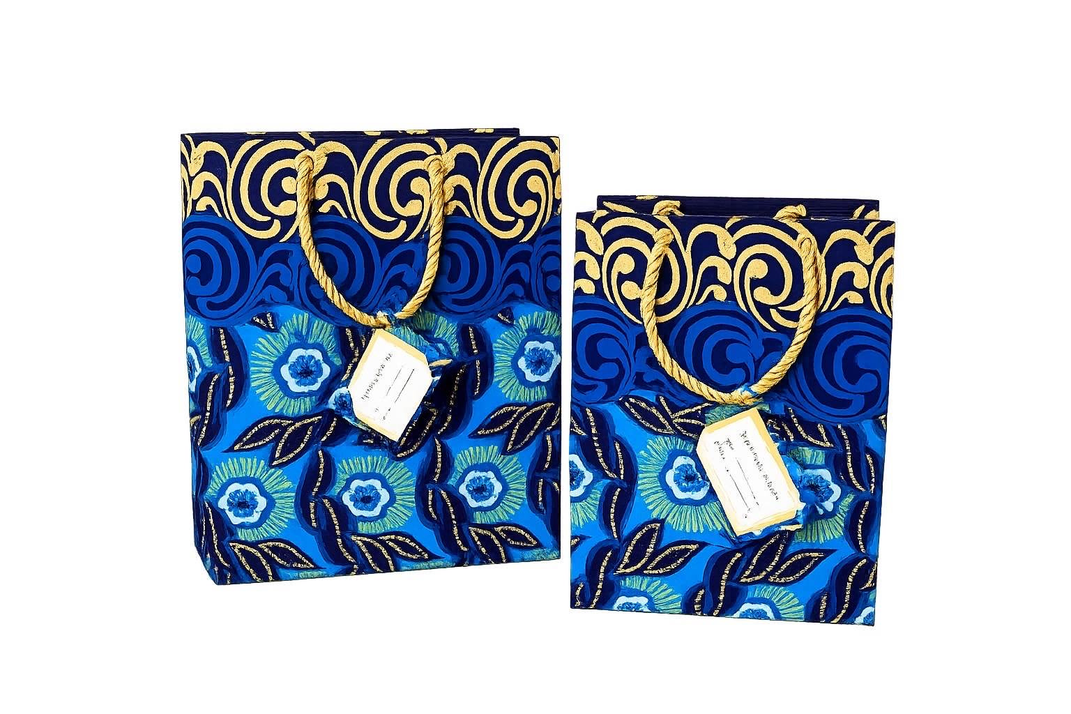 Two blue bags with gold patterns and tags on a white background