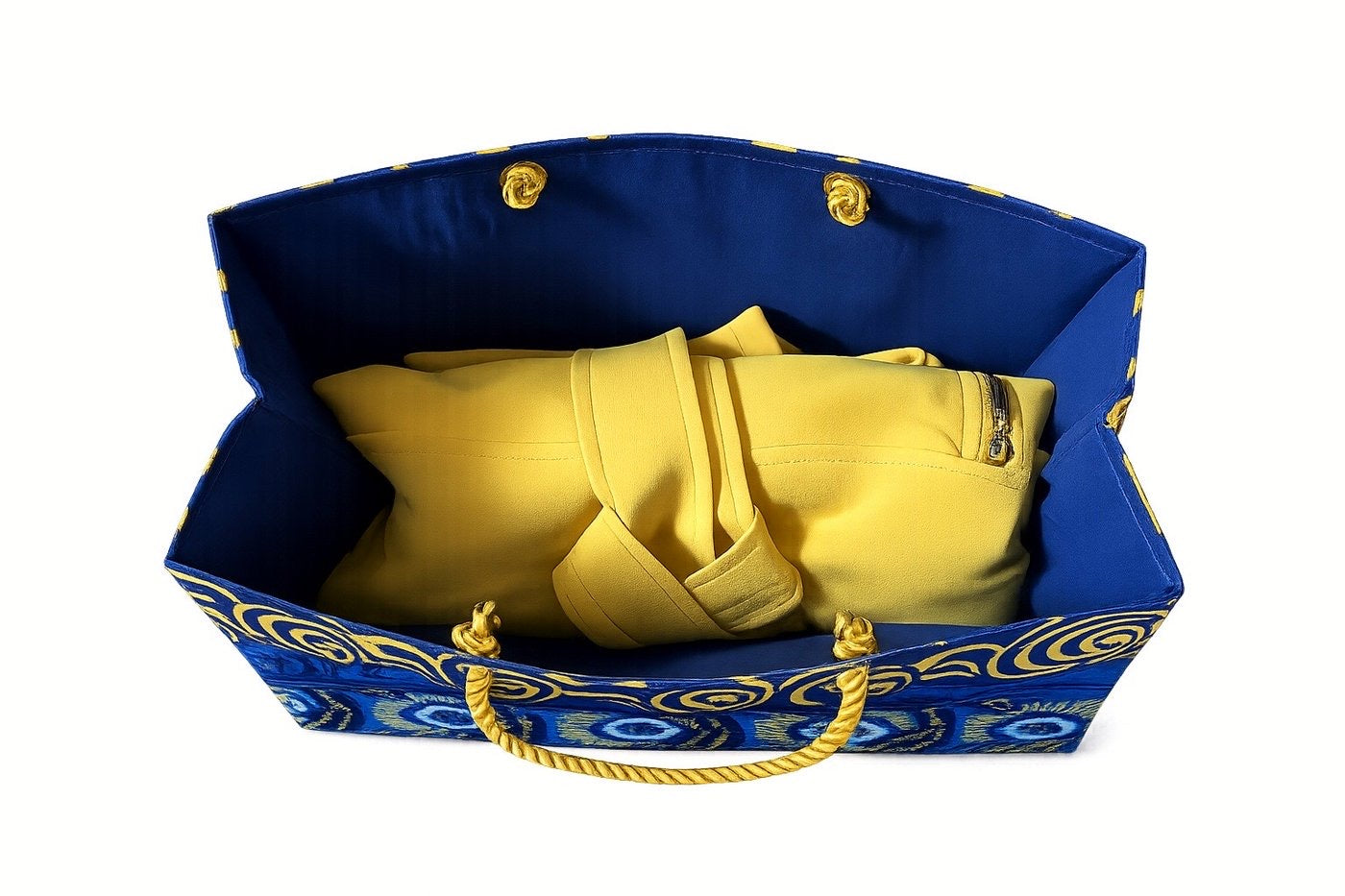 Blue, dark blue, white, and gold gift bag with yellow dress inside on a white background