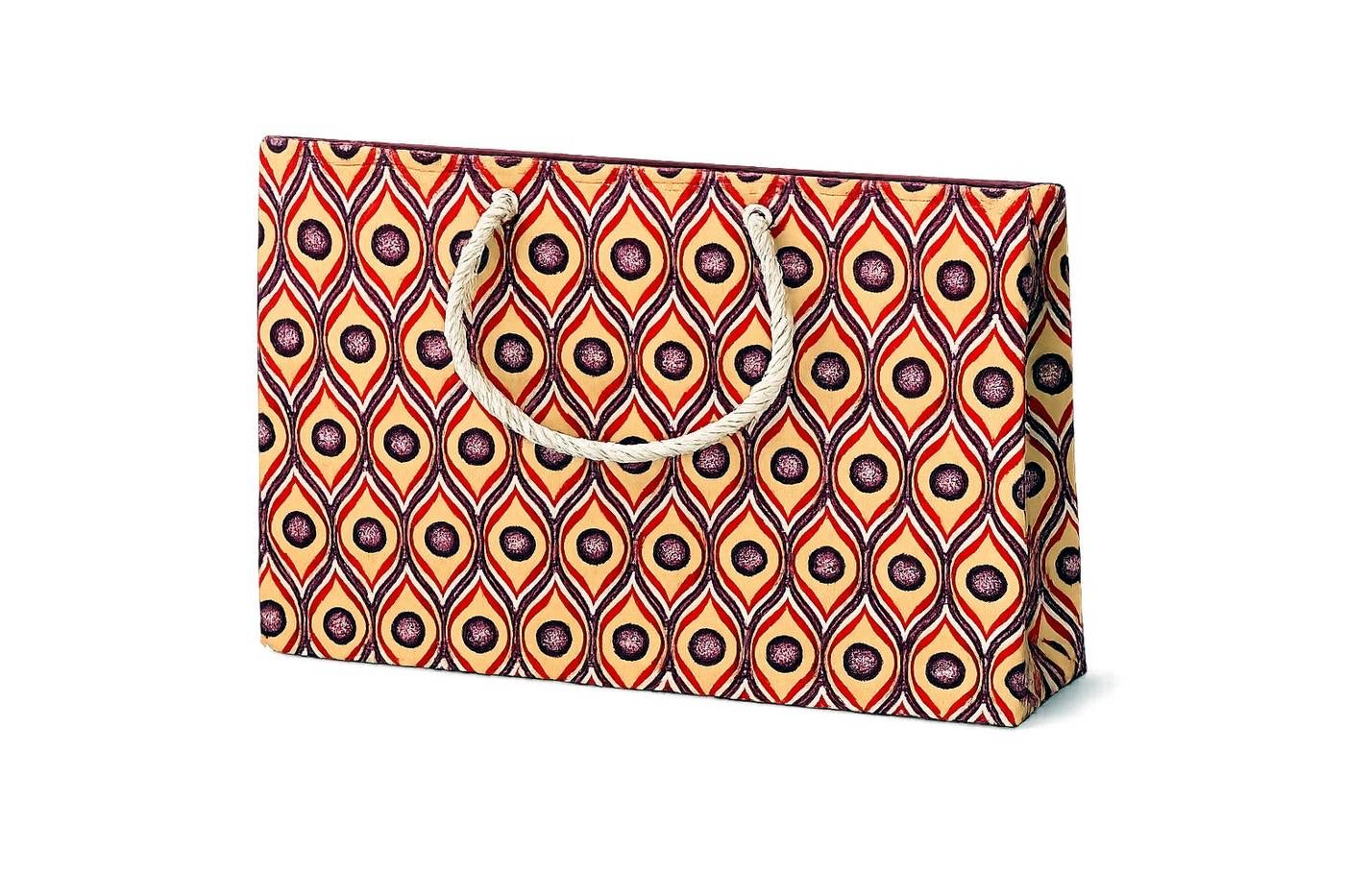 Cream, red, dark purple and white patterned gift bag with a handle on a white background