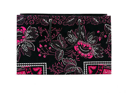 Floral patterned black, white, and fuchsia gift bag on a black background