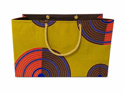 Decorative gift bag with green, dark brown, red, blue, and gold pattern on a white background