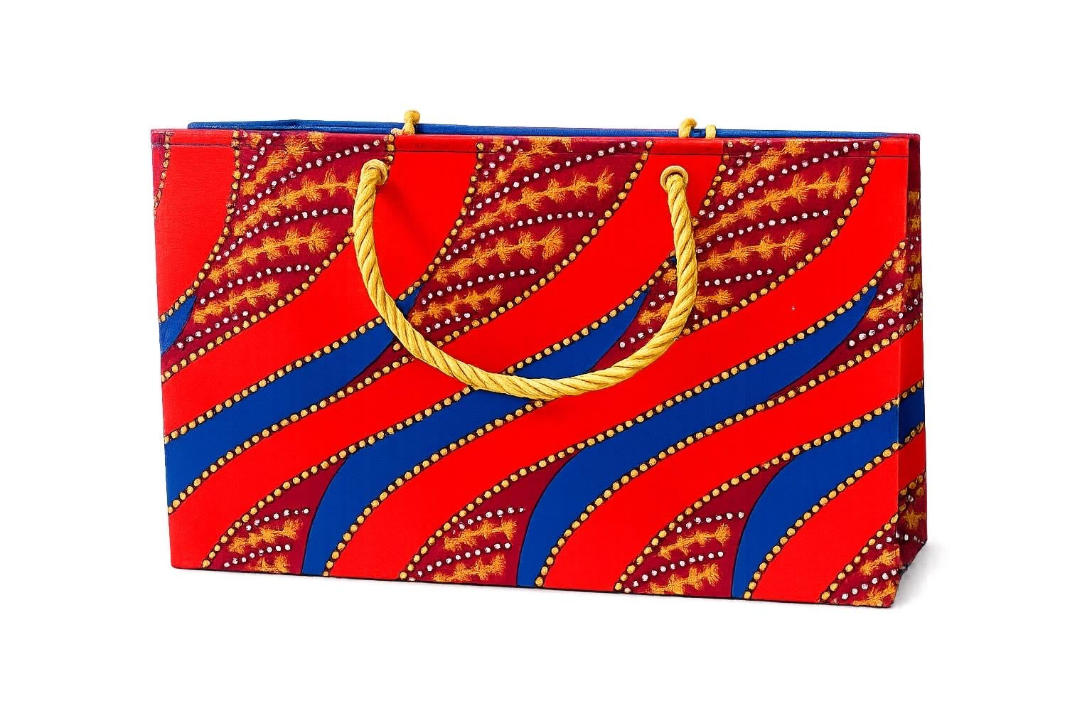 Colorful gift bag with orange, maroon, blue, and gold pattern on a white background