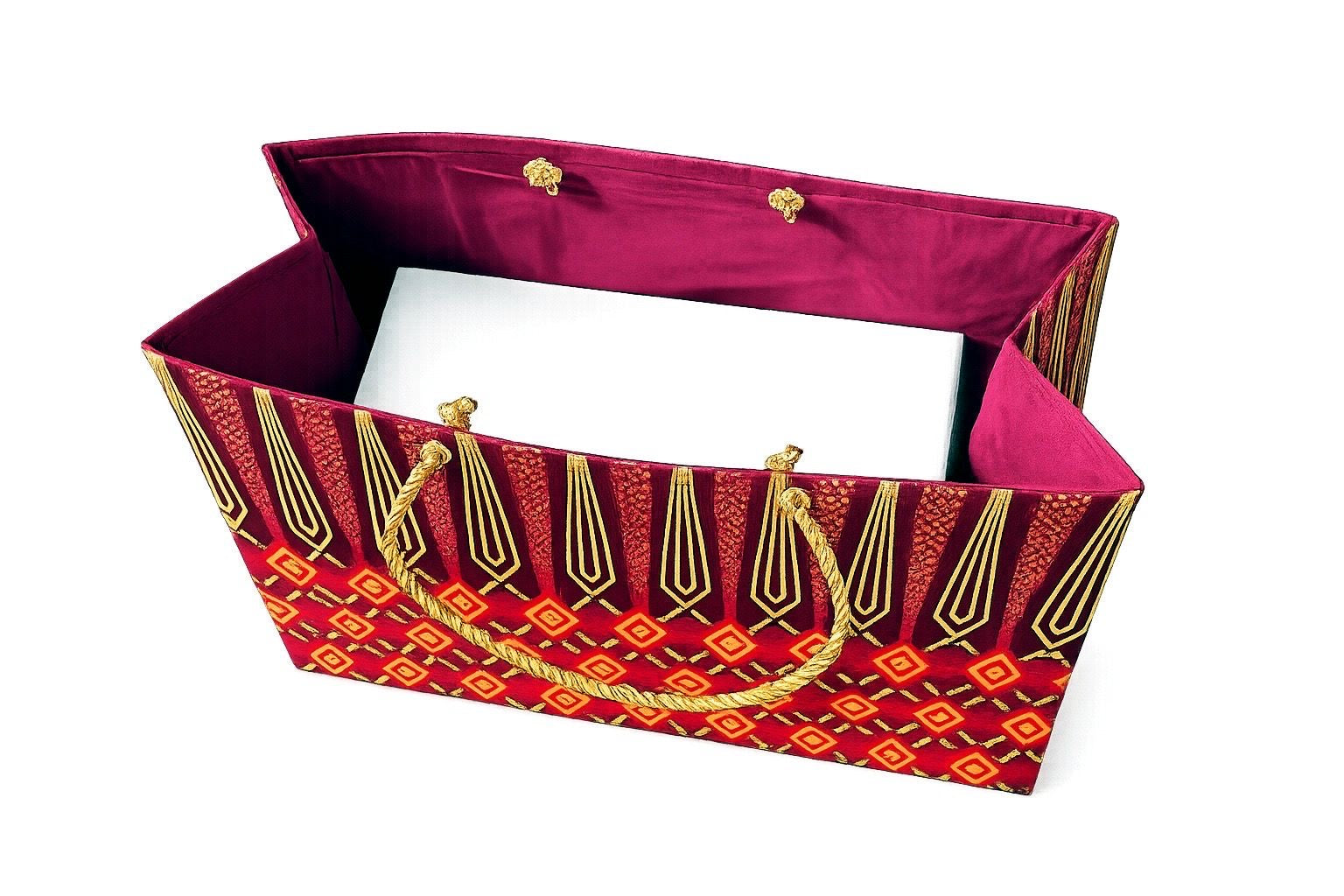 Inside view of a maroon, red and gold decorative gift bag with a white box inside and a handle on a white background