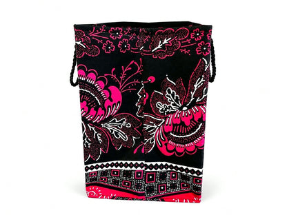 Side view of black, fuchsia, and white bag with pink floral and butterfly pattern on a white background
