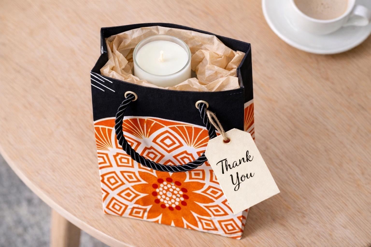 Black, orange, & white handmade African fabric mini gift bag with a thank you gift tag in lifestyle shot