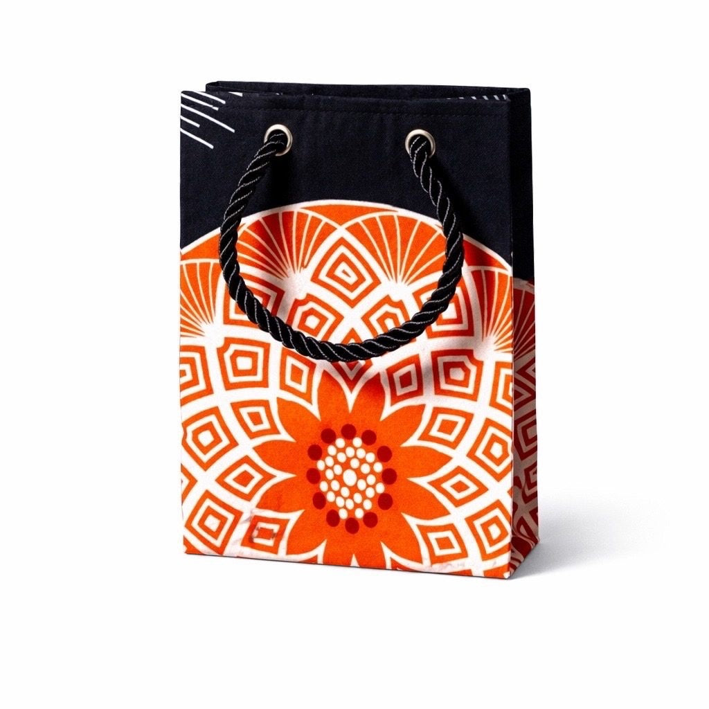 Decorative black gift bag with orange & white pattern on a white background