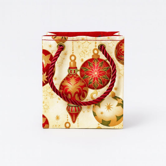 Decorative gift bag with cream, red, green, & gold pattern on a white background