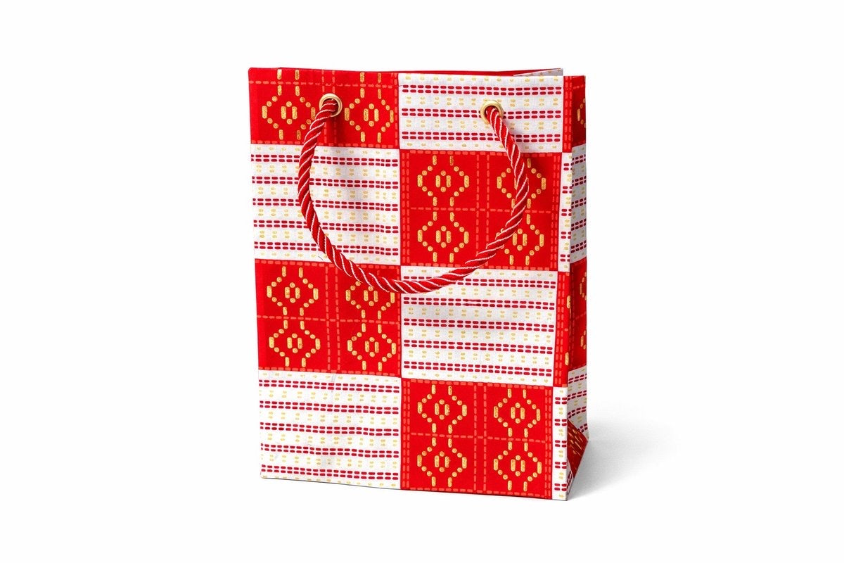 Decorative gift bag with white, red, & gold pattern on a white background
