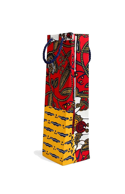 Side view of a red, yellow, white, and dark blue colorful patterned bag with red, yellow, and black design on a white background