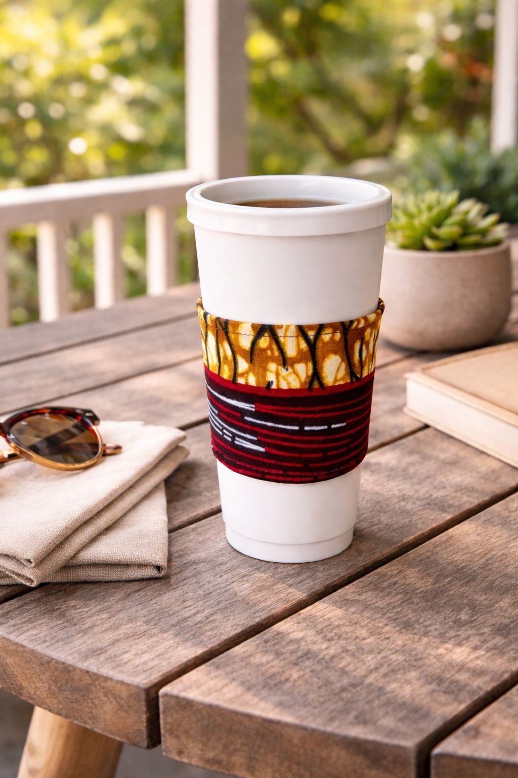 Cream, dark blue, red, brown, & white handmade African fabric cup sleeve lifestyle shot