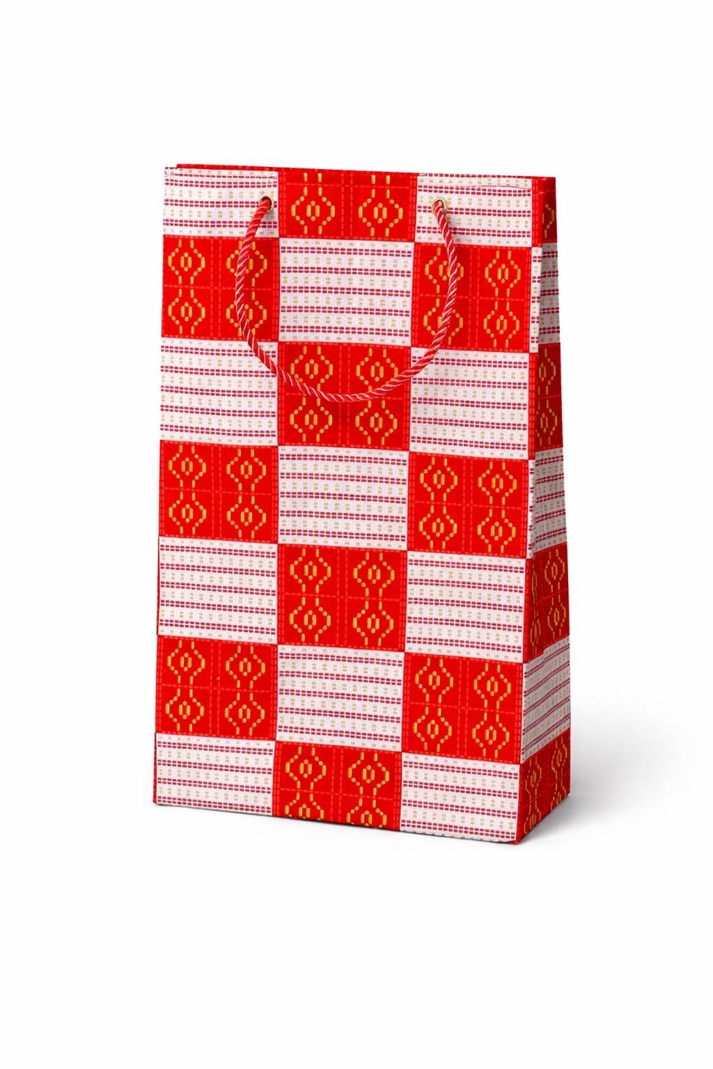 Red and white patterned gift bag on a white background