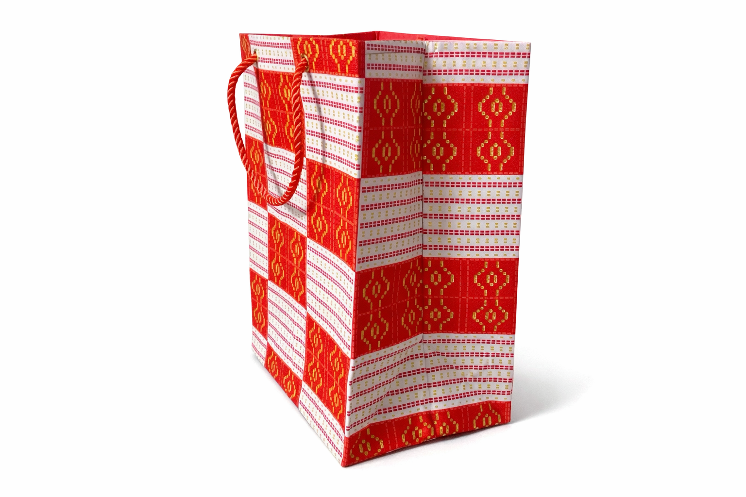 Side view of a red and white patterned gift bag on a white background