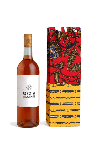 Bottle of wine with a colorful dark blue, white, yellow, and red gift bag on a white background