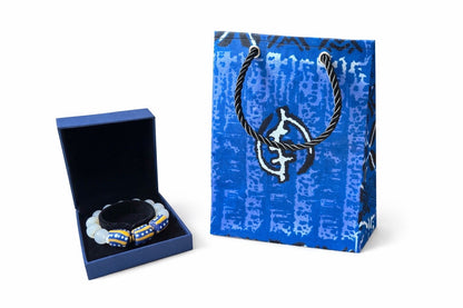 Blue, black, & white extra small gift bag with product ideas to gift on the side on a white background
