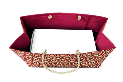 Cream, red, white, & deep purple decorative gift bag with a patterned handle on a white background