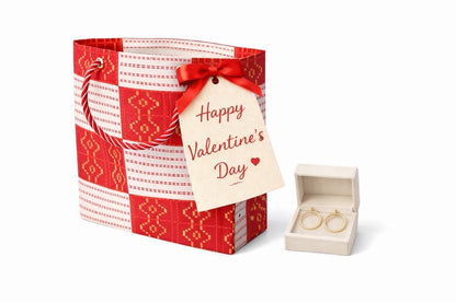Red, white, & gold gift bag with jewelry and 'Happy Valentine's Day' tag on a white background