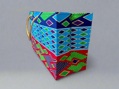 Side view of an Ethnic, Fabric, Patterned, Handmade Turqoise, Navy Blue, Red, and Green, and Gold Medium Horizontal Bag on. gray background - Gezia Accents