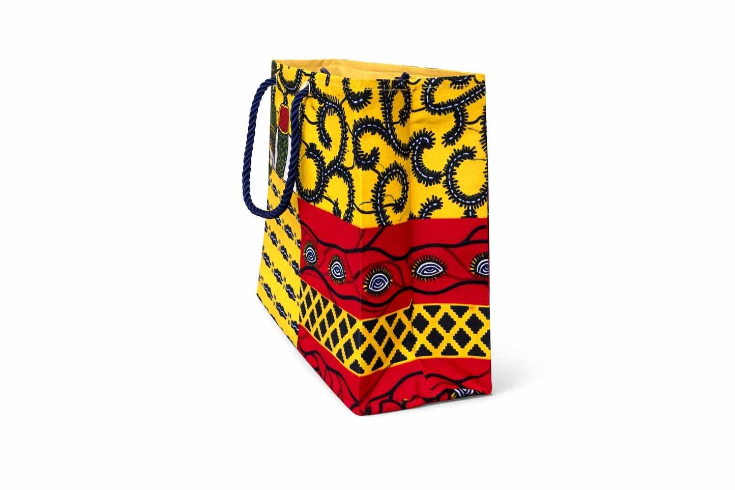Side view of set of socks, a mug with chocolates, and a colorful red, yellow, white, and dark blue patterned bag on a white background