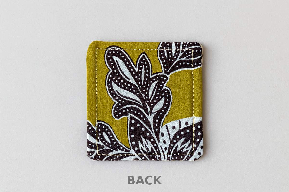 back view of green corner bookmark with  white & brown patterns on a light gray background