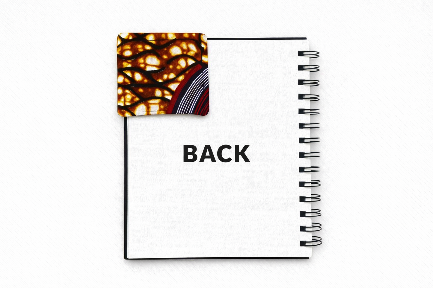 Back view of corner bookmark with brown, dark blue, maroon, & cream patterns on a light gray background