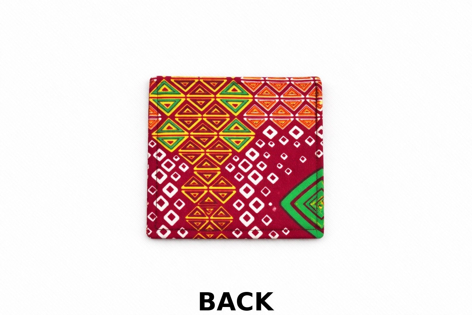 Back view of corner bookmark with red, yellow, green & white patterns on a light gray background