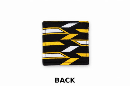 Back view of corner white corner bookmark with black & gold patterns on a light gray background