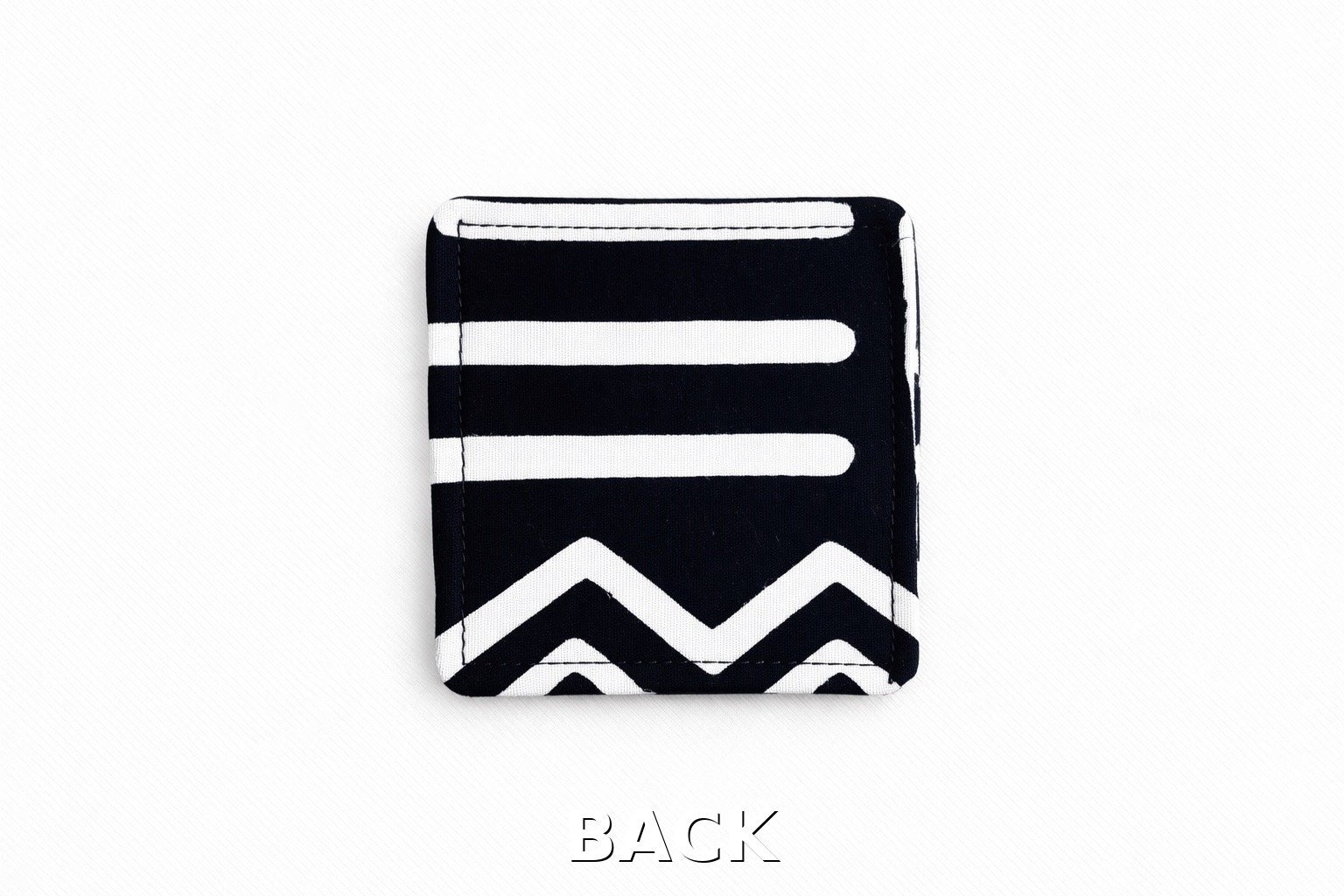 back view of black corner bookmark with white patterns on a light gray background