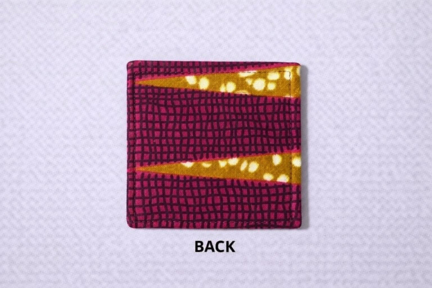 back view of corner bookmark with pink, brown, cream, & gold patterns on a light gray background