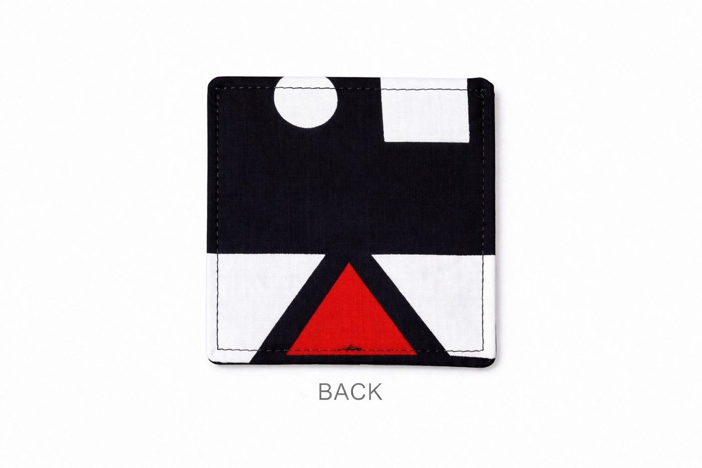 back view of a white corner bookmark with black & red patterns on a light gray background