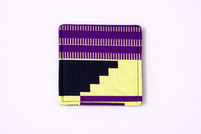 back view of yellow corner bookmark with purple & black patterns on a light gray background