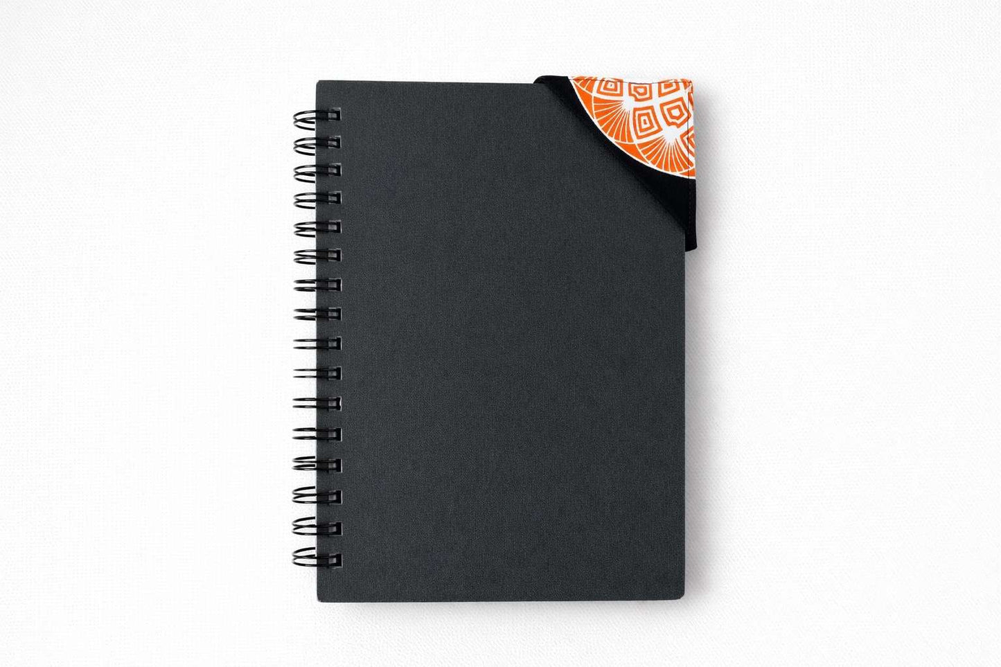 Black spiral-bound notebook with a patterned corner bookmark on a white background