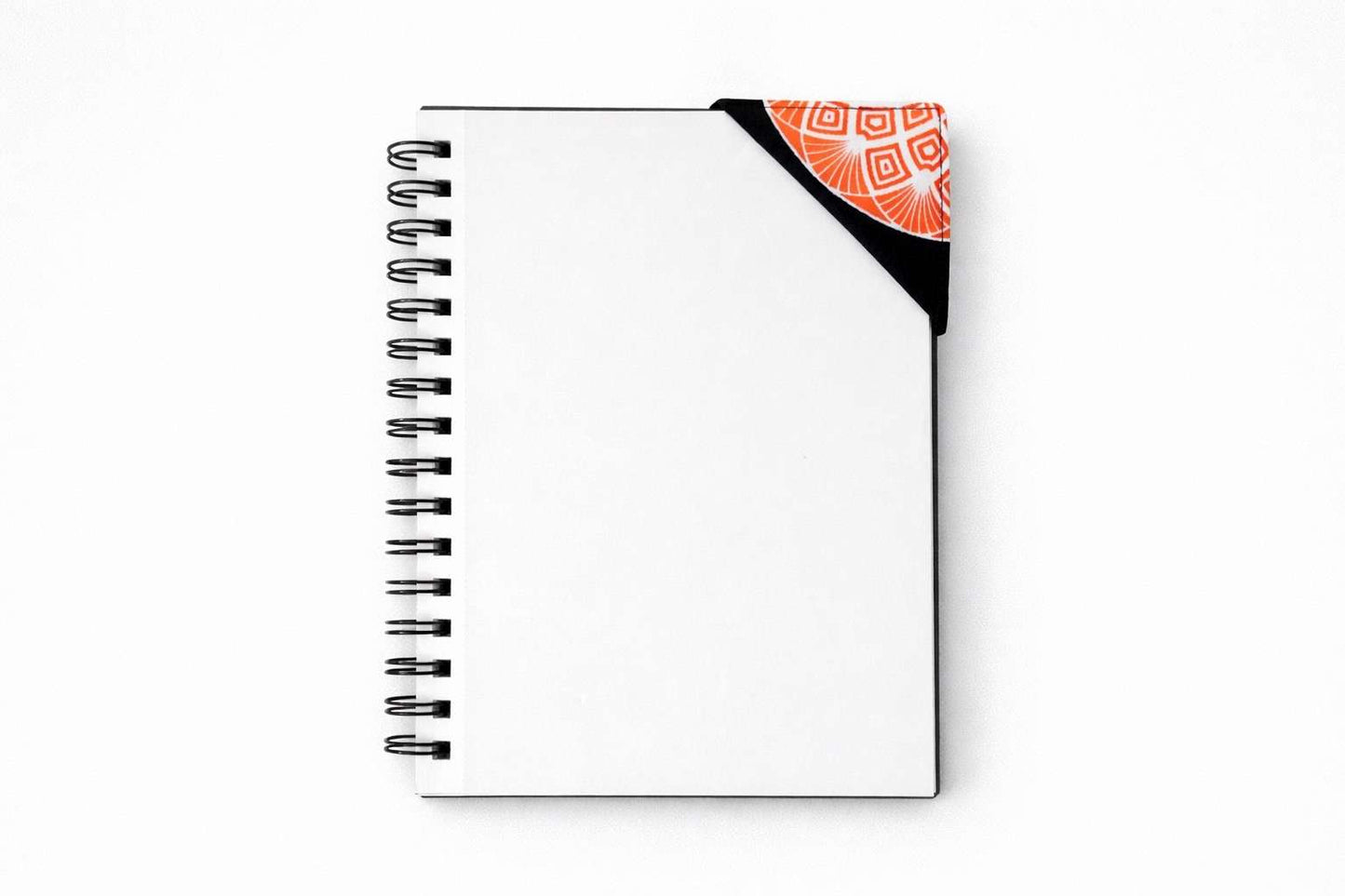 Spiral-bound notebook with a decorative corner bookmark on a white background