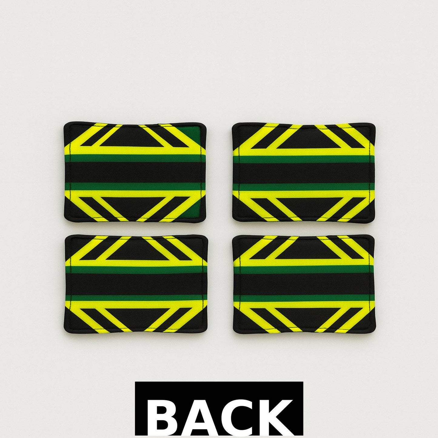Back view of 4 piece black, yellow, green, & white African fabric coasters on white background