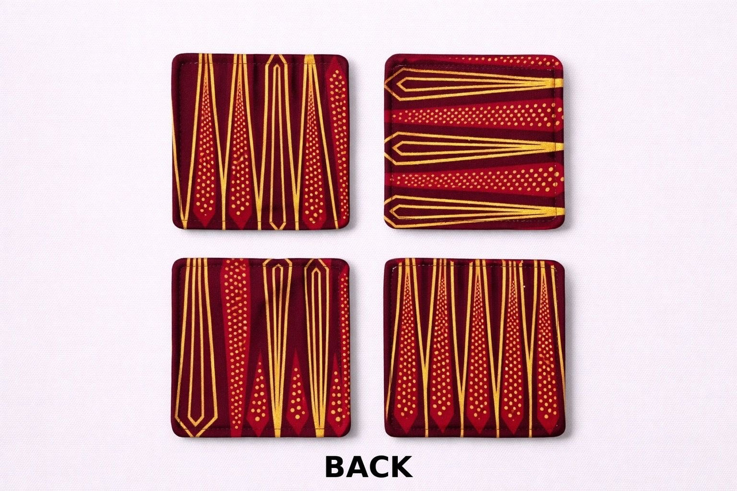 Back view of 4 maroon, red, black, & gold African fabric coasters on white background