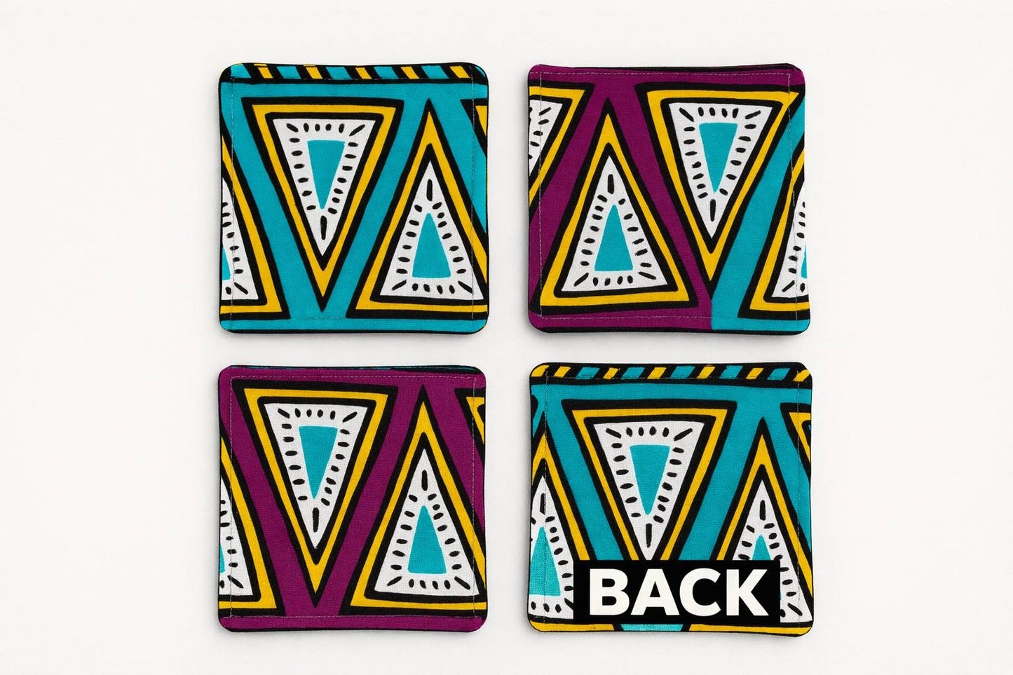 Set of 4 purple, green, yellow, beige, white, & black African fabric coasters on white background