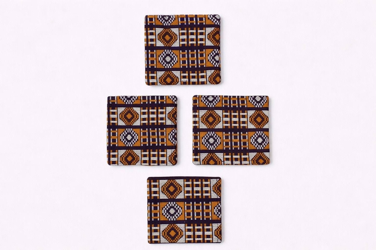 Set of 4 dark brown, orange, & gold African fabric coasters on white background
