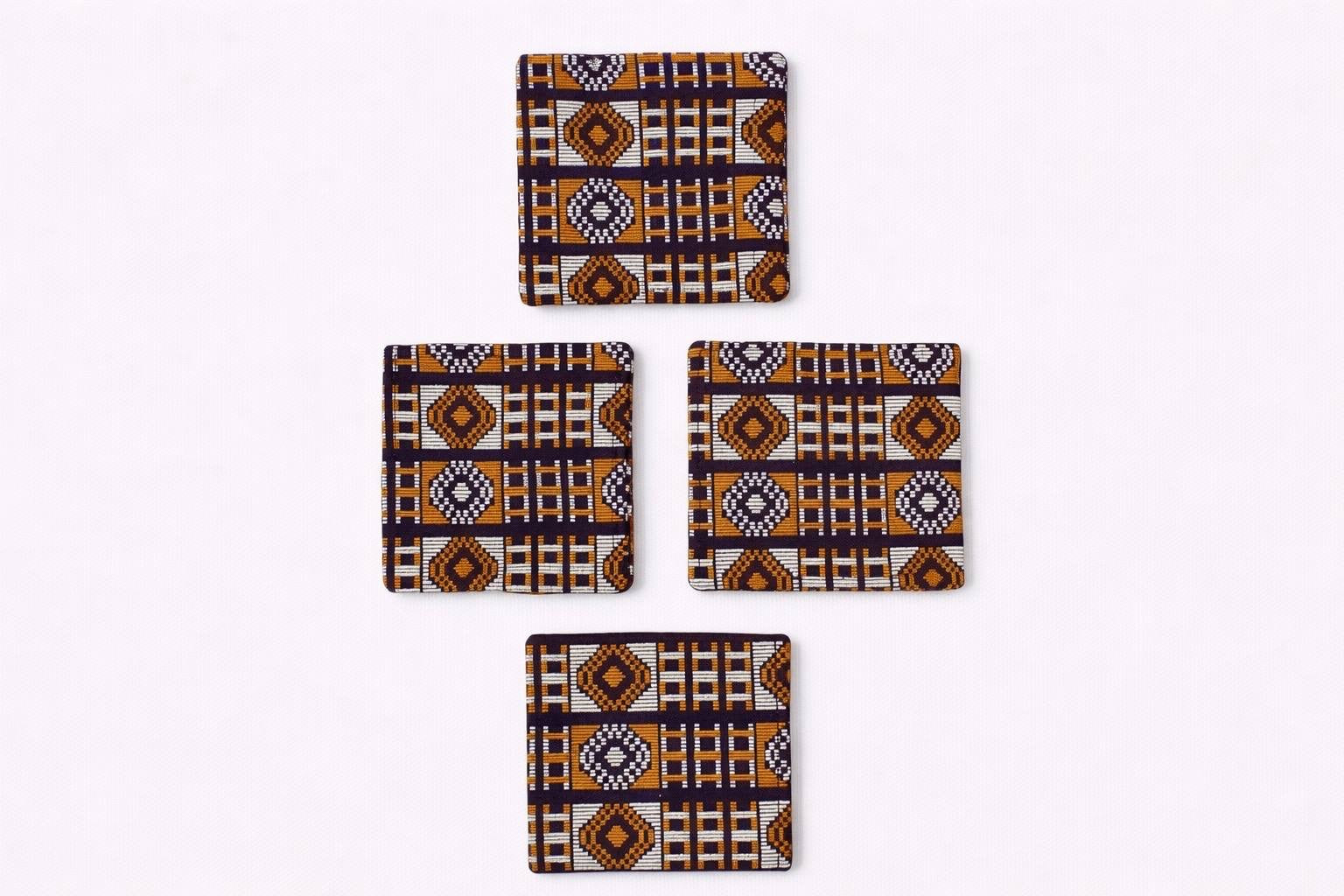 Set of 4 dark brown, orange, & gold African fabric coasters on white background