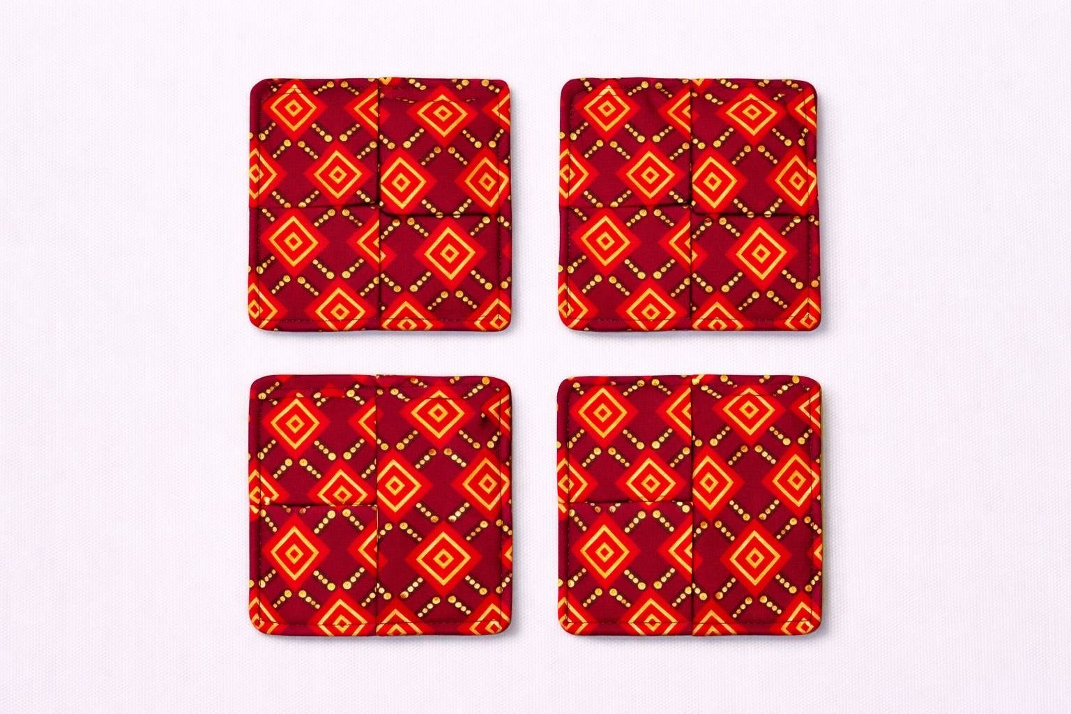 Set of 4 maroon, red, black, & gold African fabric coasters on white background