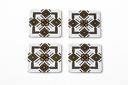 Set of 4 white, black, & gold African fabric coasters on white background