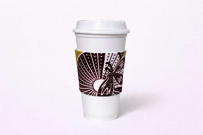 Green, dark brown, & white African wax print cup sleeve on coffee cup