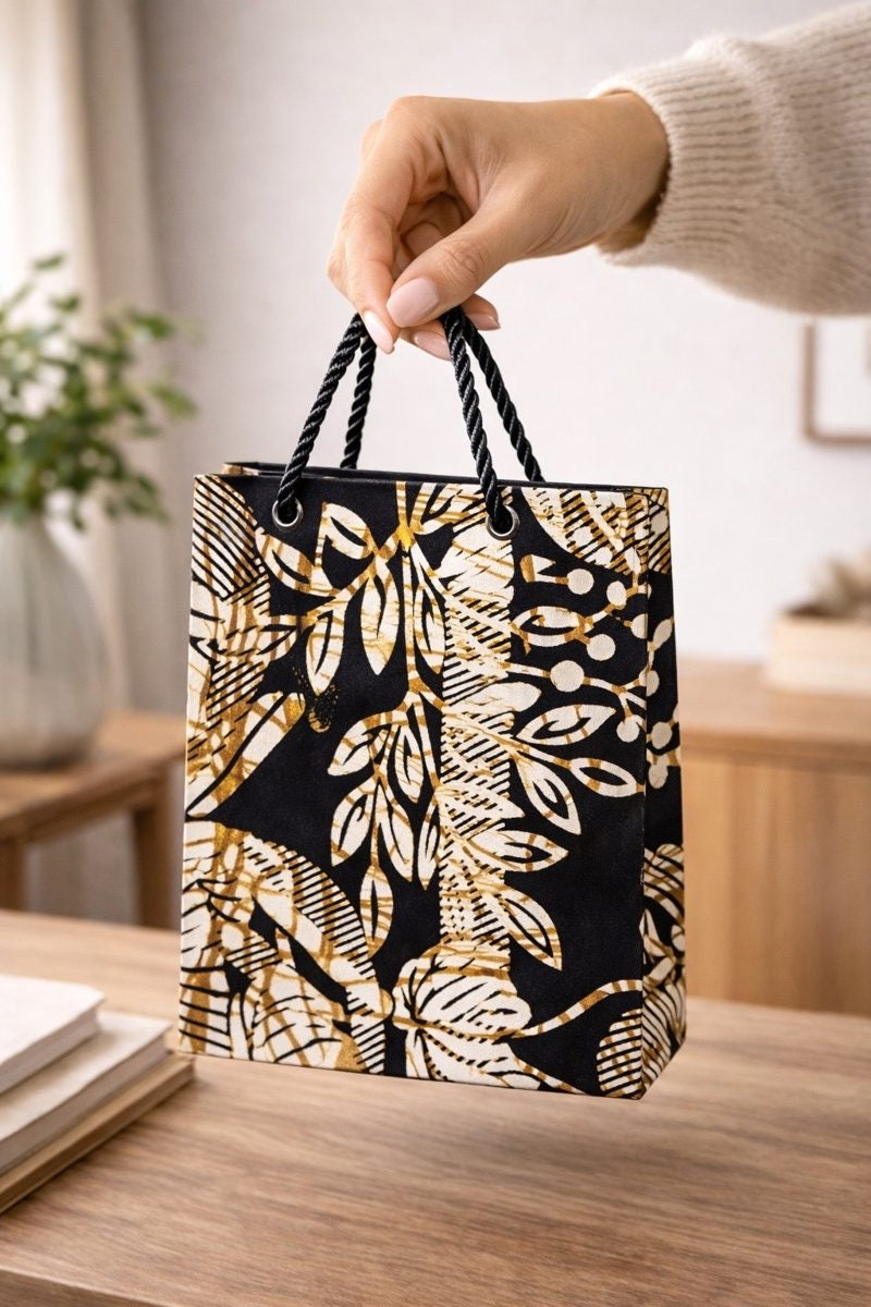 Cream, black, & gold handmade African fabric extra small gift bag in lifestyle shot