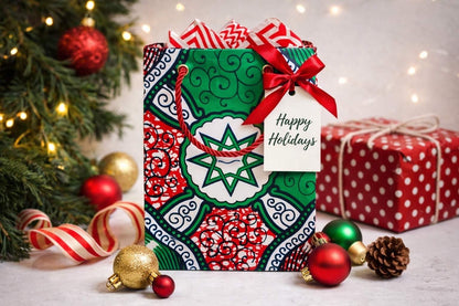 White, red, green, & black extra small gift bag on white background with Christmas tree and ornaments 