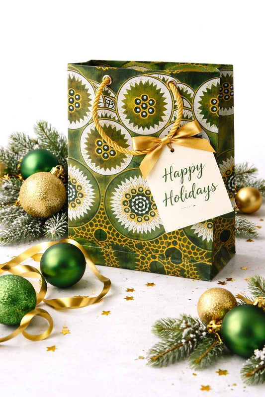 Olive green, dark green, white, & gold handmade African fabric extra small gift bag in lifestyle shot with ornaments, ribbon, & confetti