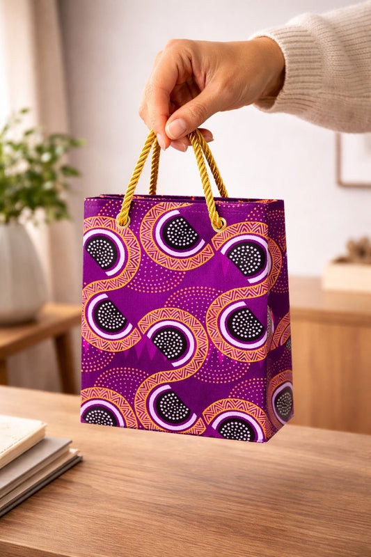 Purple, black, gold, & white handmade African fabric extra small gift bag in lifestyle shot
