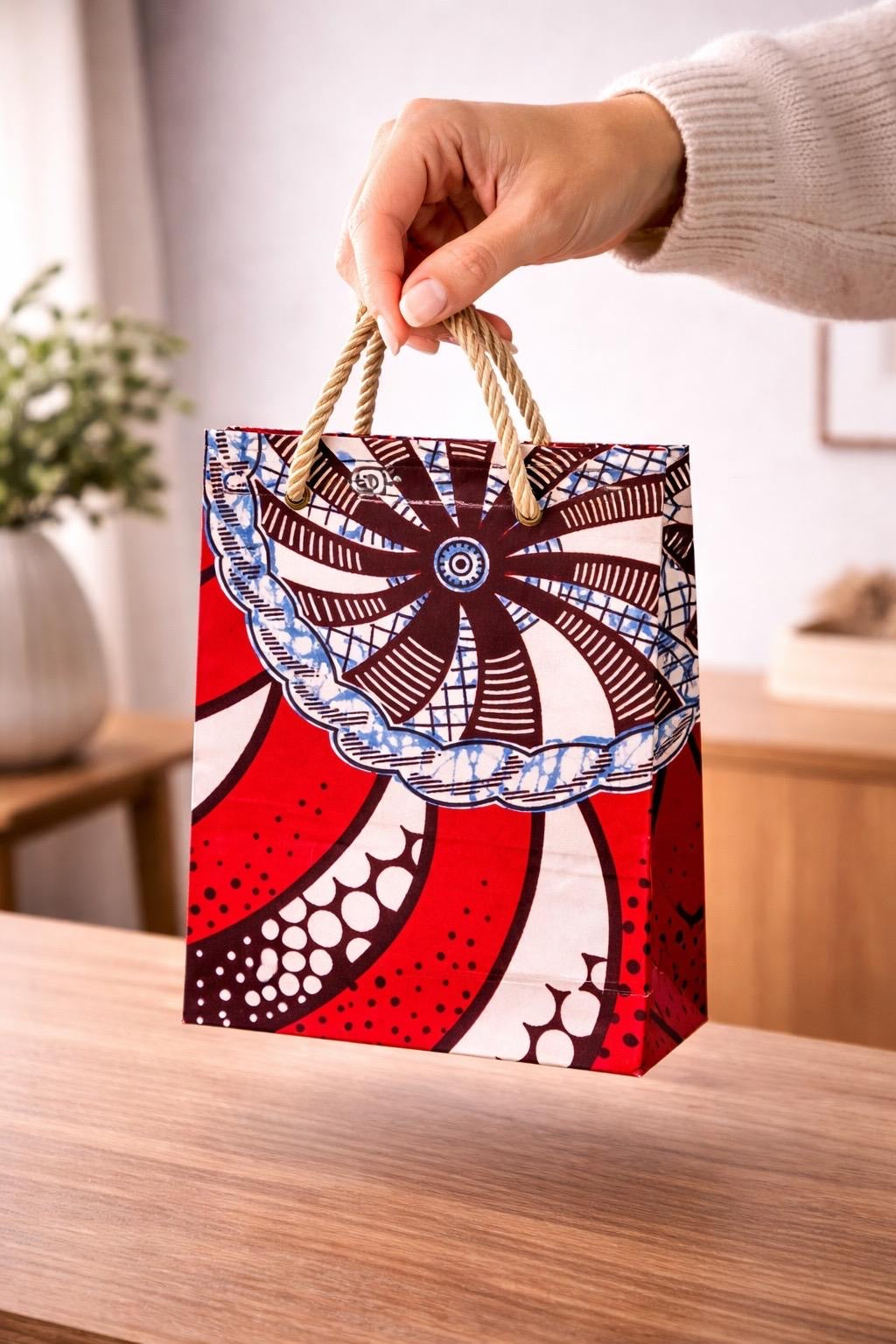 Red, dark brown, cream,  blue handmade African fabric extra small gift bag in lifestyle shot